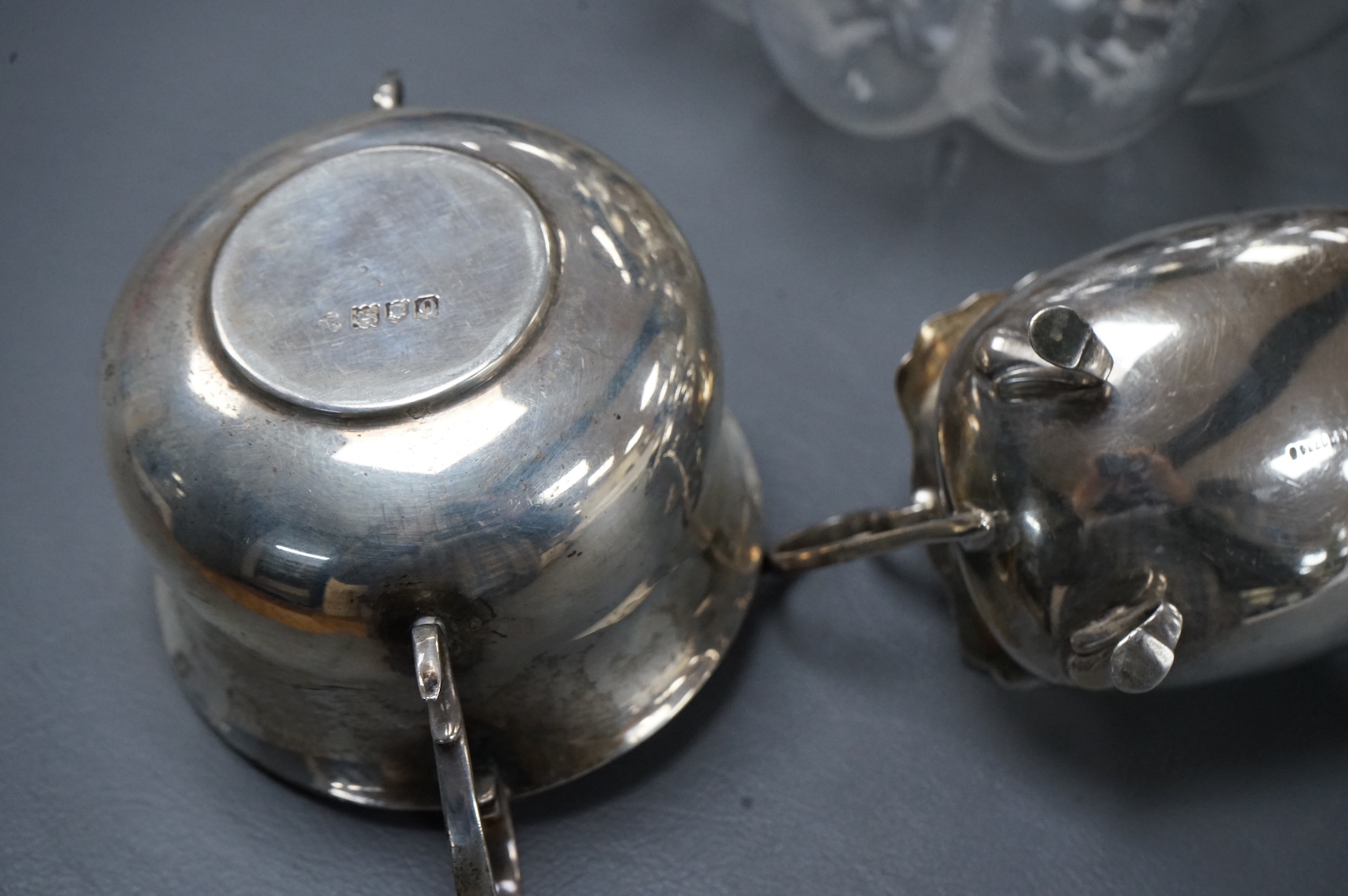 A late Victorian silver mounted lobed glass biscuit barrel by Hukin & Heath, with patent handle, London, 1899, height 14.4cm excluding the handle, together with a silver two handled condiment, a silver sugar bowl and a s